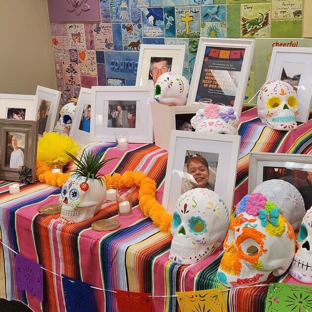 Sugar skulls on an altar with photos of donor heroes