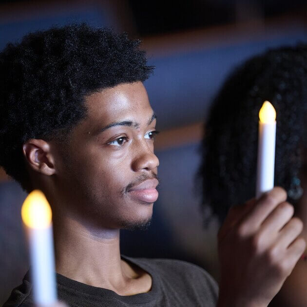 A donor family member holds up a candle