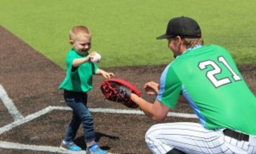 Liam puts a ceremonial first pitch in the glove of the catcher.