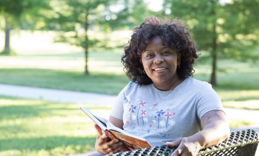 Kidney recipient Venus reading in a St. Louis park.