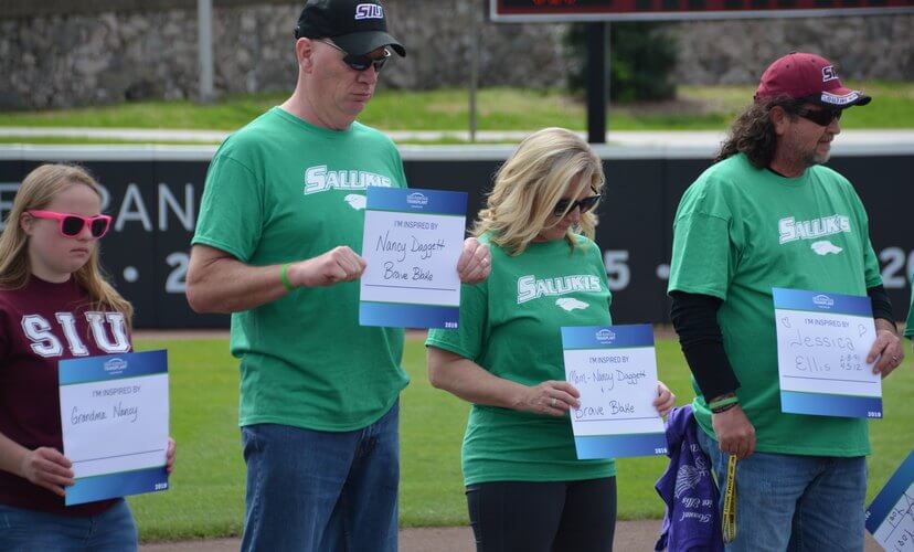 Families hold signs with the names of those who inspire them before the 2019 SIU-C Green Up Game.