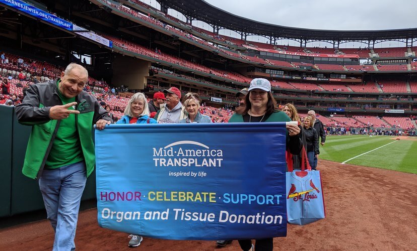 Donor families carried banners around the warning track at Busch Stadium as part of Transplant Awareness Day with the St. Louis Cardinals.