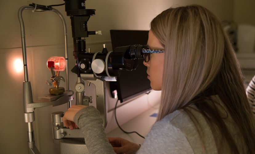 A Mid-America Transplant eye bank technician examines a cornea.