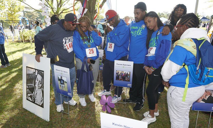 The family of EJ Harris gathers around his tribute sign in the Garden of Heroes at the Celebrate Life 5K.