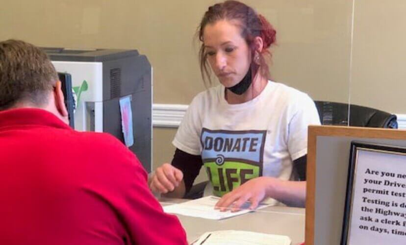 A license office worker engages with a customer.