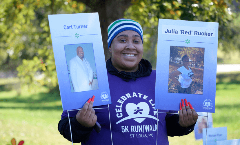 A participant holds up signs with the names and pictures of loved ones who have given the gift of life.