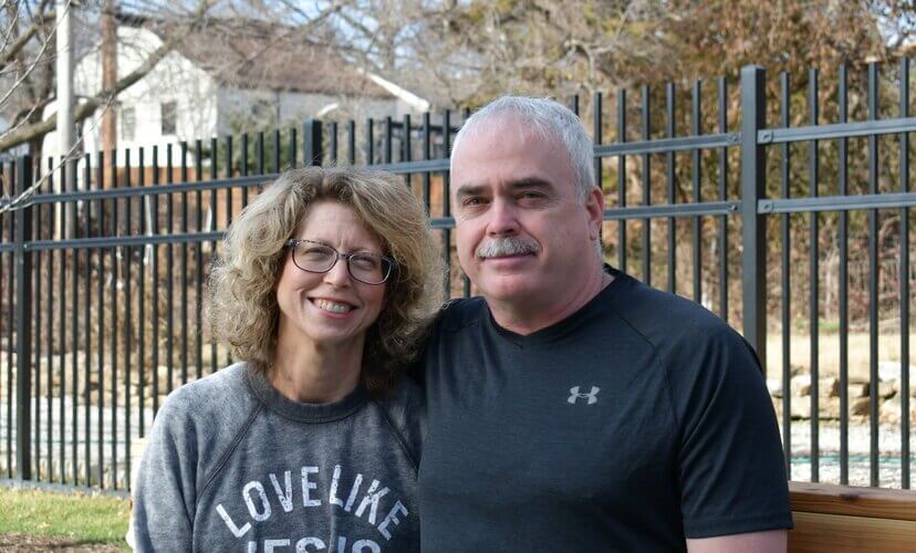 Cindy and her husband Jim sit on a bench outside the Mid-America Transplant Family House