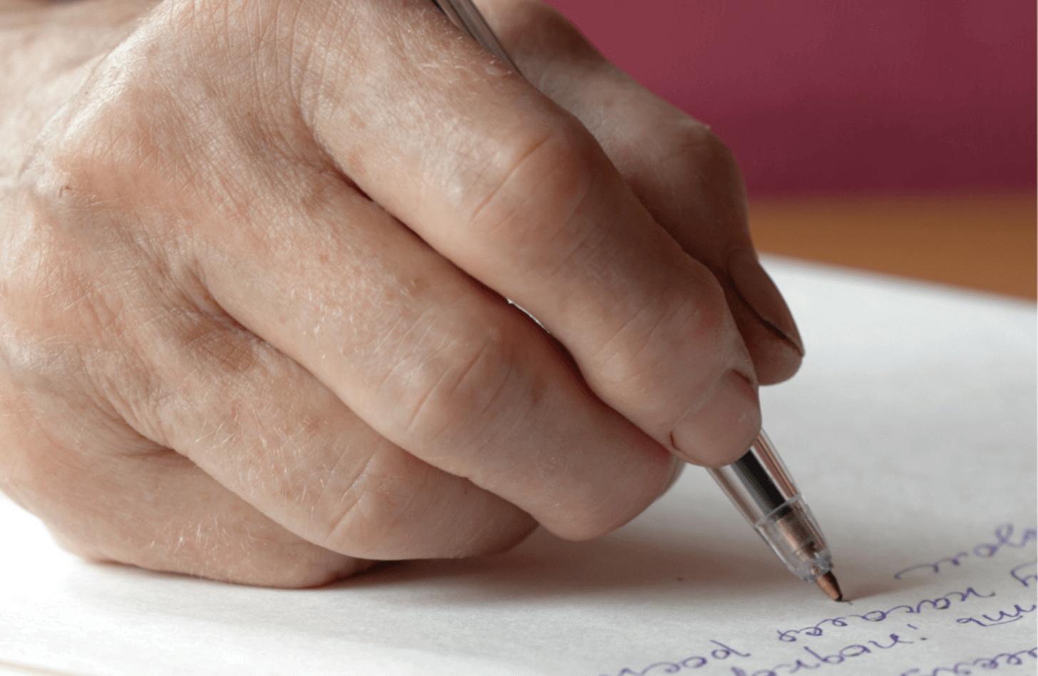 A hand writing a letter
