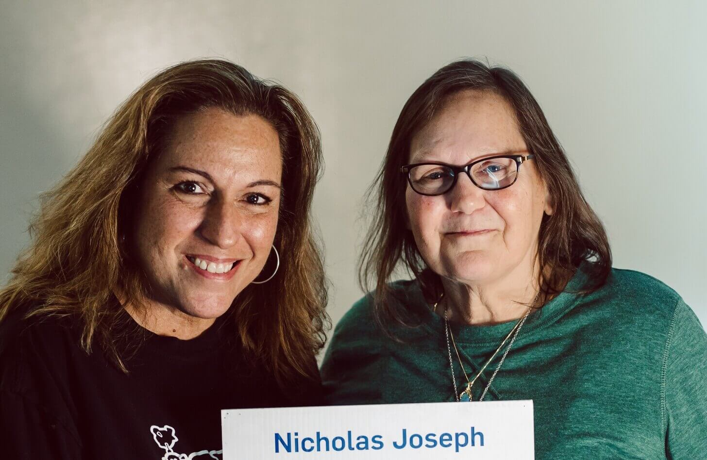 Two women hold a photo of an organ donor.