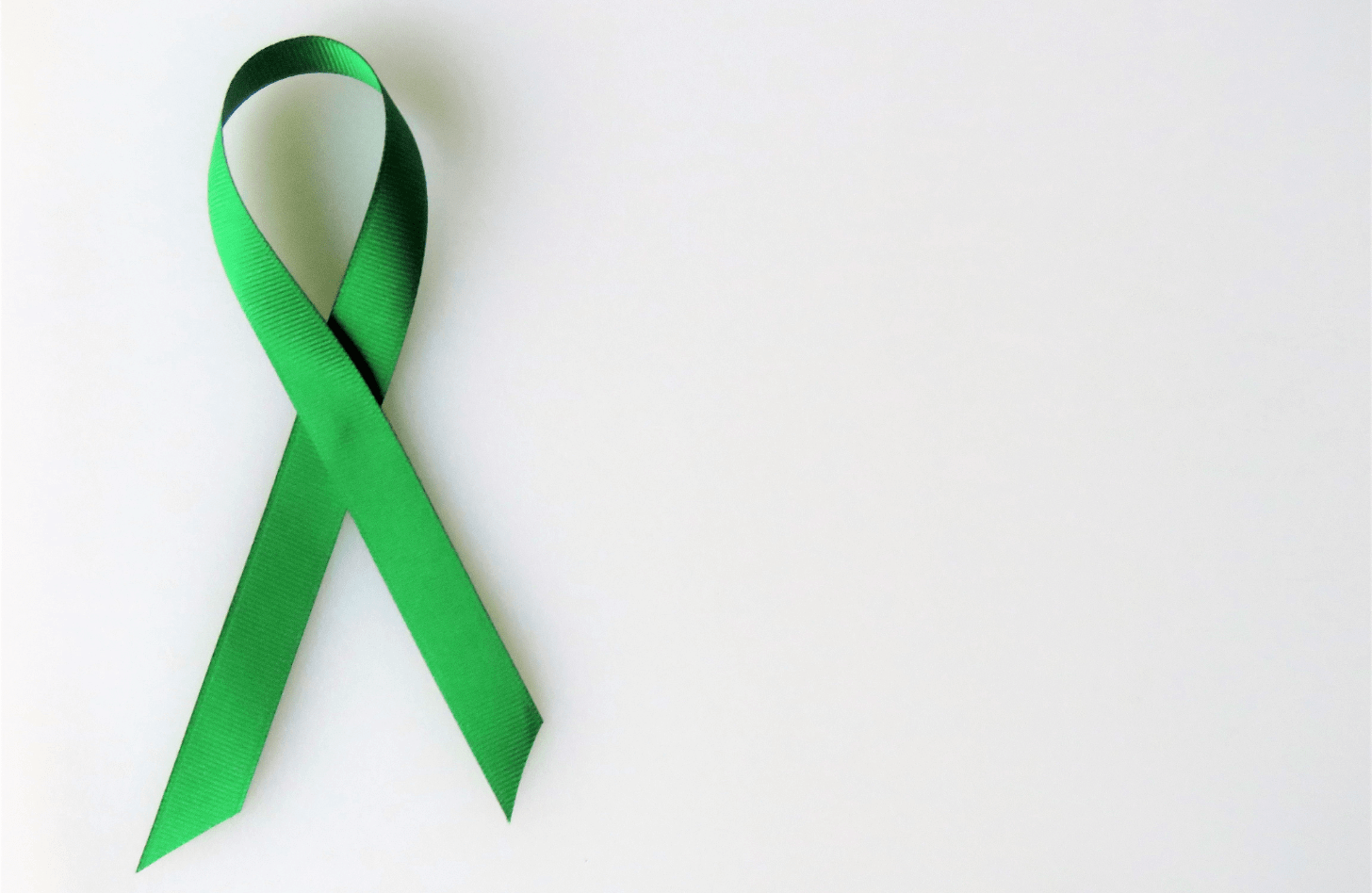 Green awareness ribbon against a white background