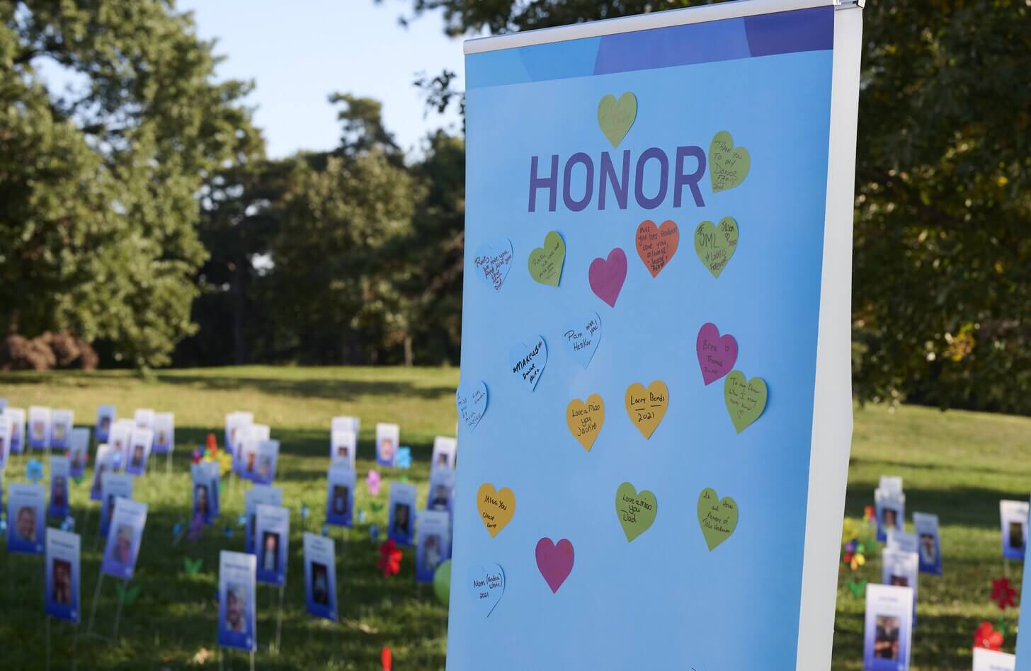A display of notes honoring donor heroes stands in front of a garden of photos honoring those who gave the gift of life
