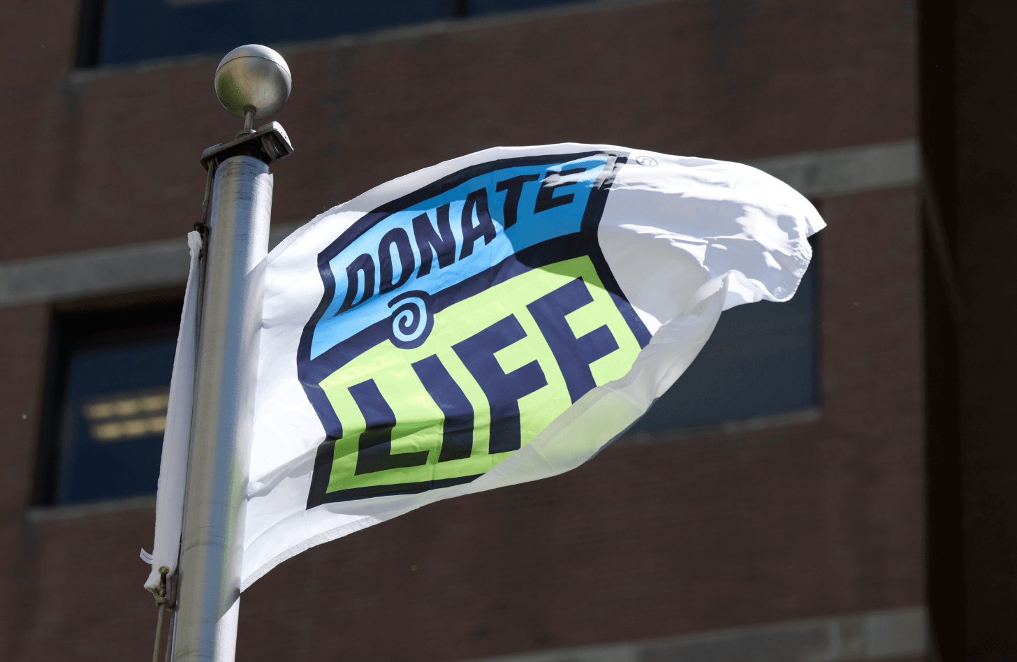 A flag with the Donate Life logo on it waves in the wind