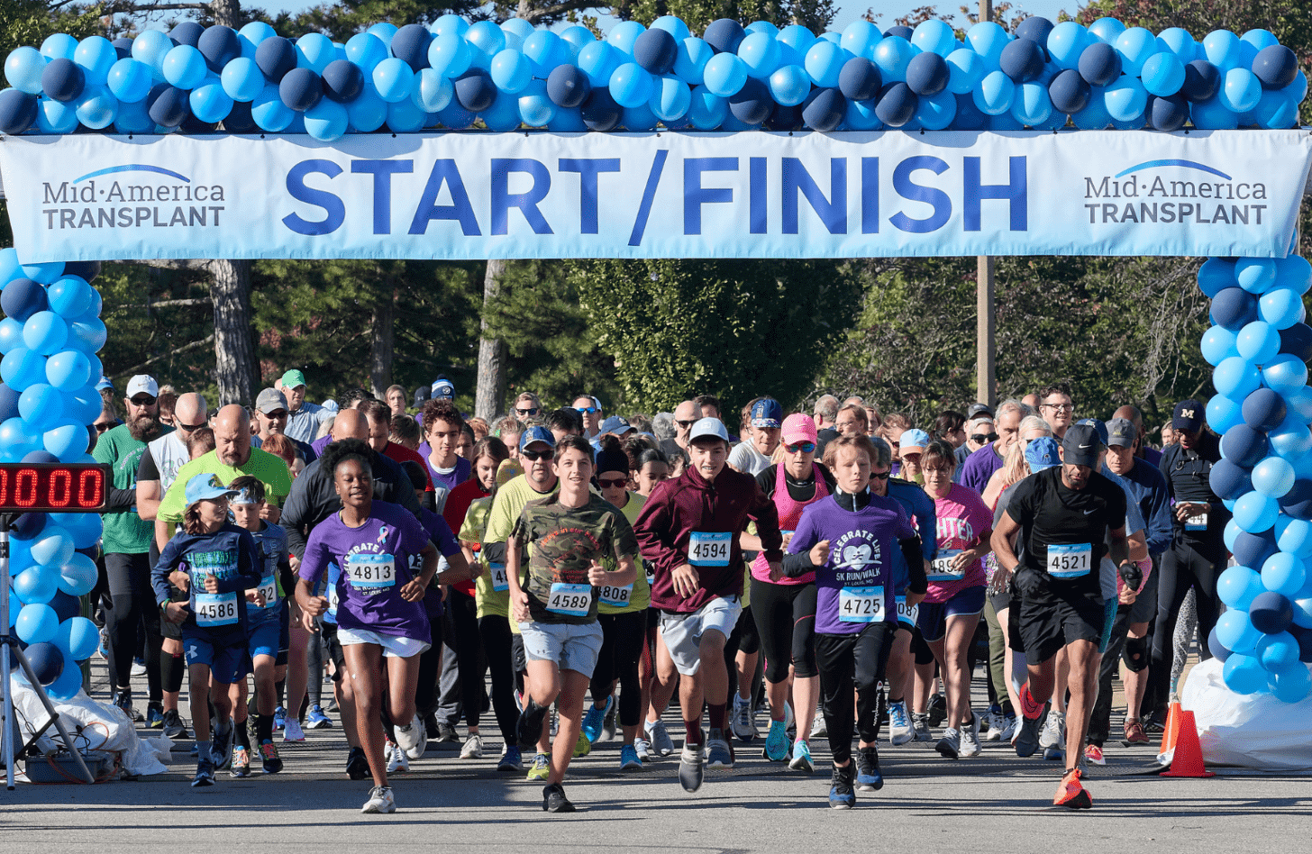 A large group of runners take of at the starting line at the Celebrate Life 5k