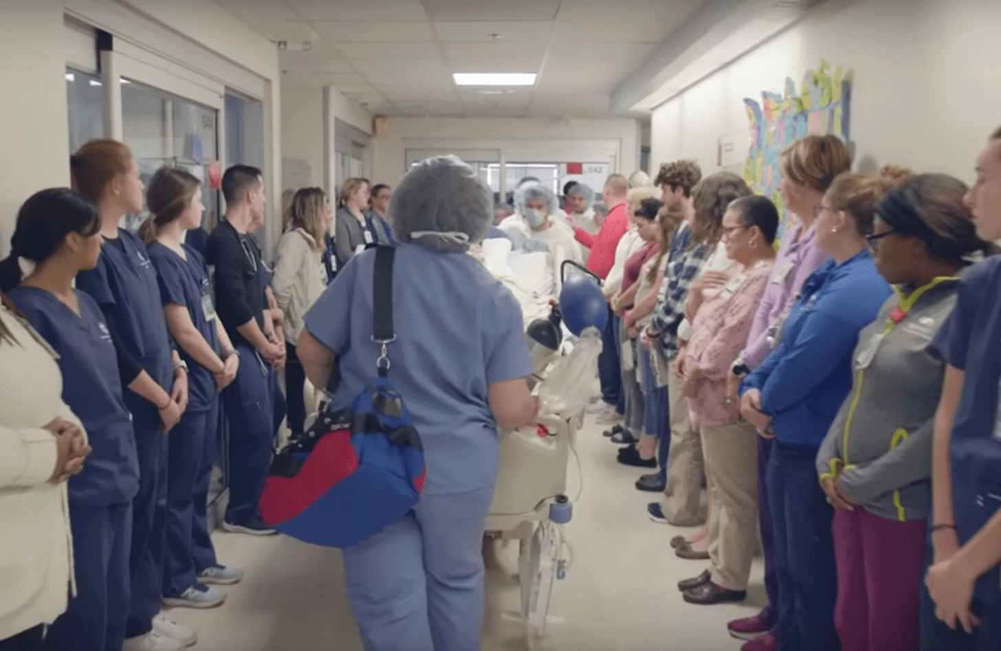 A donor is wheeled up the hallway during an honor walk