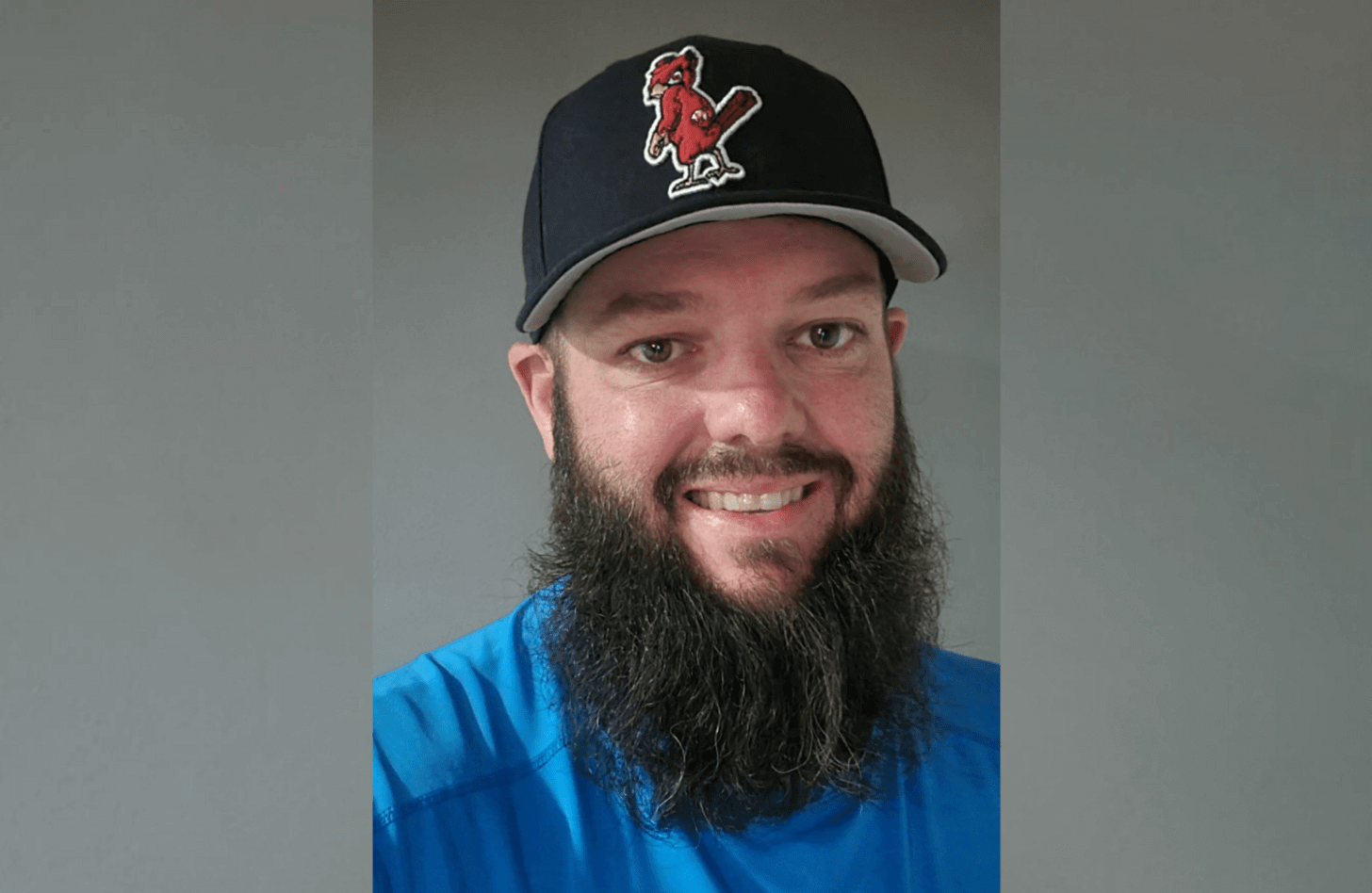 Dan, a Triage Coordinator, has a long beard and wears a blue shirt and ballcap.
