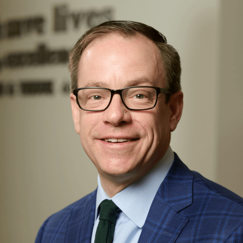 Kevin Lee, President & CEO, Mid-America Transplant. He is wearing glasses and a blue plaid suit jacket
