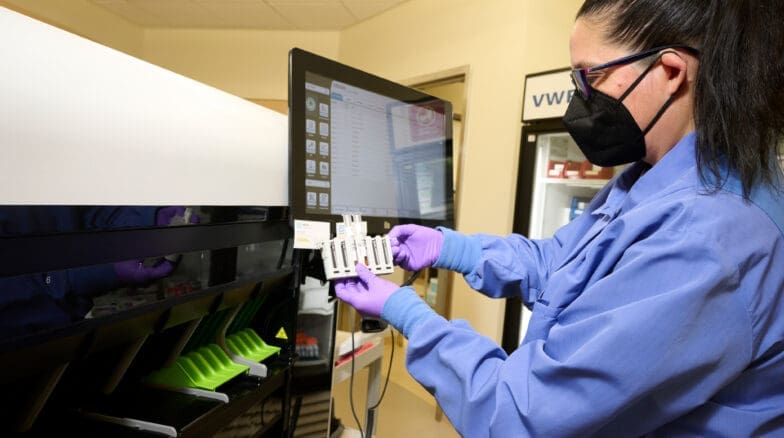 Woman in medical facility holding viles