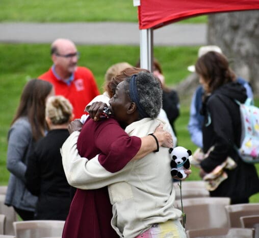 Donor families hug at a candlelight memorial event